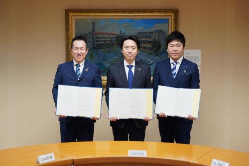 協定締結の様子。2市1町の首長と協定書。